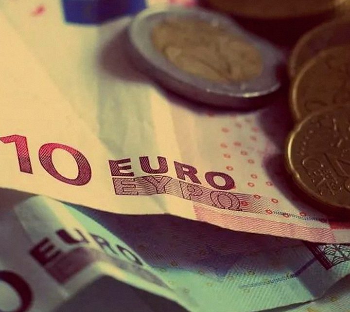 Billetes de euro y monedas apiladas sobre una superficie
