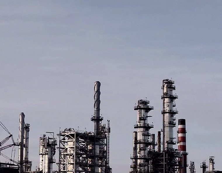 Torres y chimeneas de un complejo industrial bajo un cielo plomizo