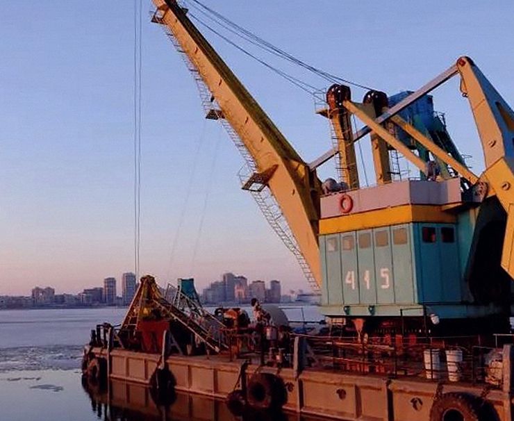 Grúa sobre una barcaza en un puerto al caer la tarde